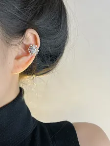 Primer plano detalle de manguito de oreja perla circonita girasol, diseño de clip sin perforar.