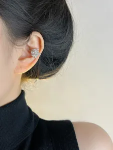 Detalle de pendiente de oreja girasol circonita, elegante joya sin perforación para mujer.