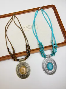 Dettaglio collana a sovrapposizione di perline bohemien, ciondolo rotondo vintage turchese.