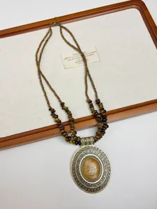 Collana di perle a doppio strato vintage con ciondolo ovale intagliato e pietra naturale.