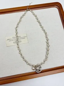 Gedetailleerd overzicht van de parelketting met glinsterende zirkonia schommelpaard hanger voor dames.