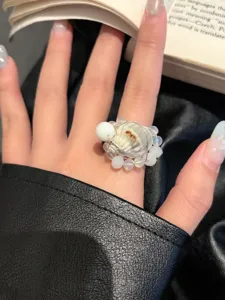 Nahaufnahme eines handgefertigten Muschel- und Perlenperlenrings im Urlaubsstil Schmuck.