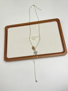 Primo piano sul dettaglio della lunga collana con ciondolo chiave in metallo stile vintage.