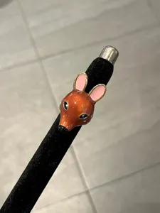 Primo piano sul dettaglio dell'anello con testa di cervo smaltata, orecchie rosa e pois.