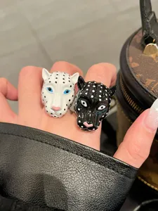 Primo piano dettagliato di anelli con testa di animale distintivi indossati, gioiello di tendenza.