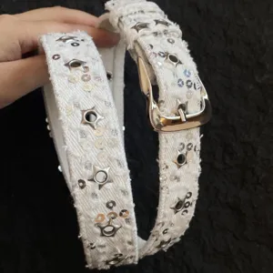 White denim belt detail shot with star grommets and sequins, perfect for Y2K punk outfits.