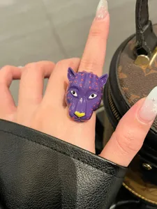 Squisito anello con testa di leopardo viola in smalto, elegante gioiello di lusso.