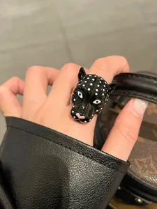 Primo piano dettagliato dell'esclusivo anello con testa di pantera in smalto a pois.