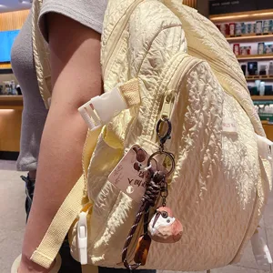 Cute resin wood-carving style bird keychain paired with a stylish crinkled casual backpack.