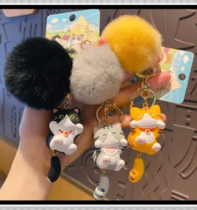 Close-up of cute plush cat keychain, showing fluffy pom-pom and creative cartoon kitten.
