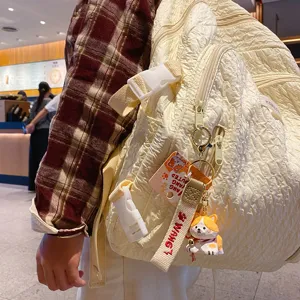 Light yellow quilted backpack with cute corgi pendant and stylish strap, perfect daily fashion accessory.