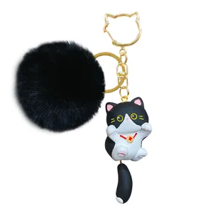 Cute black cat keychain with fluffy plush pom pom and gold metal hook for bags and keys.