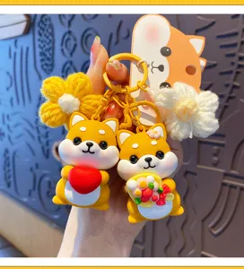 Close-up detail van schattige Shiba Inu sleutelhanger met hart en gebreide bloemenhangers.
