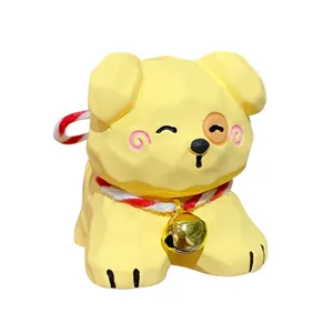 Mignonne figurine de chien en bois jaune avec clochette doree et corde rouge et blanche.