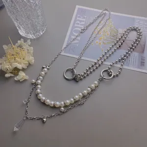 Detailed view of the multi-layer pearl waist chain with crystal drop and metal chains.