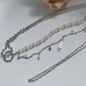 Detailed view of the multi-layer pearl body chain with crystal charms and metal beads.