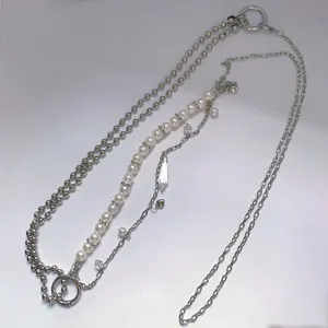 Detailed shot of multi-layer pearl and metal hip-hop body chain with crystal drop pendant.