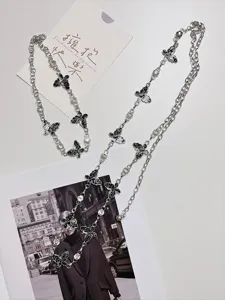 Details van een stijlvolle metalen vlinder ketting riem met sprankelende strass steentjes.