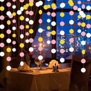 Hanging paper dot garland decoration, pink white and gold circles for party wedding setup.