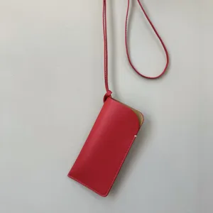 Detailopname van een stijlvolle rode lederen brillentas opbergtas met nekband.