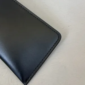 Close-up detail van zwarte lederen etui met nette stiksels voor een mooie weergave.