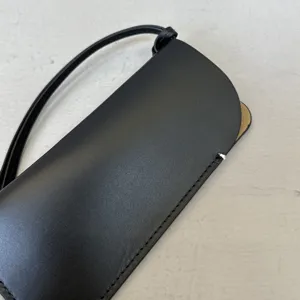 Detail van zwart lederen nekbrillenhoesje, minimalistische draagbare zonnebrilopslagaccessoi