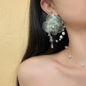 Detaillierte Nahaufnahme von mintgrünen Mesh Blumenohrringen mit Perlen und Kristallen.