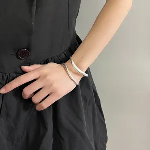 Minimalistisches doppellagiges, gebürstetes offenes Metallarmband im Detail, eleganter Stil.