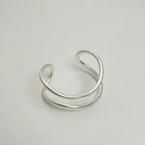 Detailansicht des minimalistischen offenen Armbands aus Metall mit gebürsteter Oberfläche.
