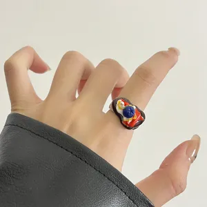 Gros plan détaillé d'une bague de type design de niche mini nourriture avec glaçage goutte.