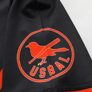 Detailed view of the black sports uniform sleeve featuring an orange bird logo embroidery.
