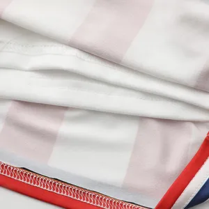 Kids cheerleading uniform fabric detail shot, pink and white stripes with neat stitching.