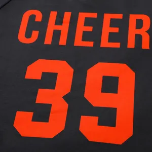 Close-up detail shot of children cheer costume featuring bold orange letter and number print.