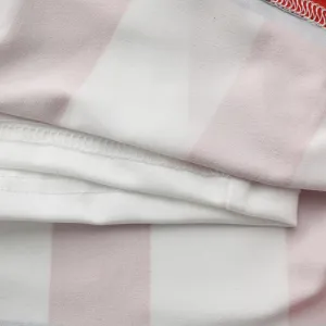 Close-up detail of pink and white striped fabric apparel featuring clean and neat stitching.
