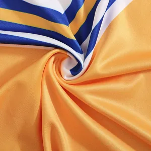 Detailed view of bright orange cheerleading costume fabric with blue and white stripes texture.