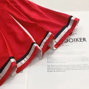 Rode geplooide cheerleader rok met witte en donkerblauwe strepen voor toneelvoorstelling.