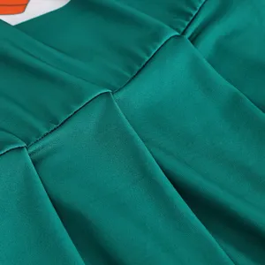 Dettaglio del tessuto del costume da cheerleader, vestito plissettato verde primo piano