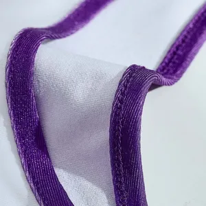 Kids cheerleading costume detail view, purple metallic trim and white fabric, close-up.