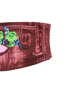 Detailed view of stretch faux denim shorts featuring elastic waistband and green floral print.
