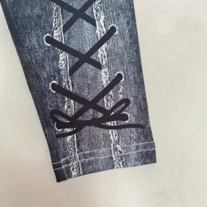 Close-up detail of women's fashion printed leggings with denim texture and lace-up bow.