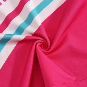 Kinder Cheerleading Uniform Stoff Detail zeigt leuchtend rosa, weiße und blaue Streifen.