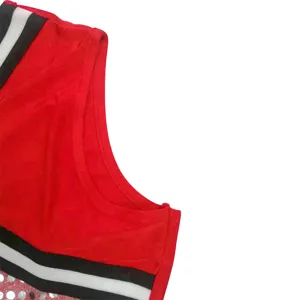 Red cheerleading uniform top detail with black white stripes and sparkly sequins.