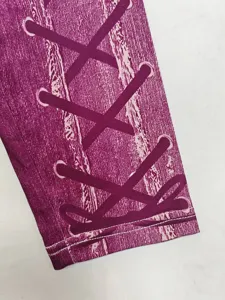 Detailed close up view of women purple fitness yoga leggings with faux lace up print.