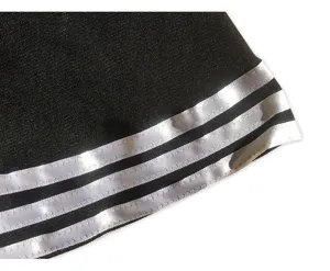 Cheerleader skirt detail featuring classic black fabric with triple white stripe hem trim.