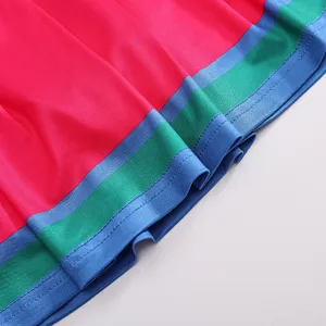 Details of kids cheerleader uniform hem, colorful striped fabric design, performance wear.
