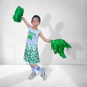 Children cheerleader costume detail, green and white shamrock print performance uniform set.