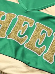 Close-up detail view of the cheerleading uniform fabric featuring glitter print.