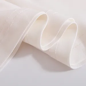 Detailed close-up of white performance costume fabric featuring fine stitching and smooth elastic folds.
