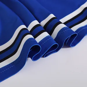 Child cheerleading uniform dress detail showing blue pleated fabric with colorful stripes.