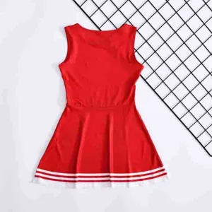 Red sleeveless cheerleading dress detail showing the flared skirt with white stripe hemline.